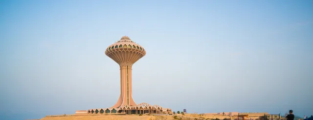 Torre ornamentada de celosía en una plaza elevada al atardecer
