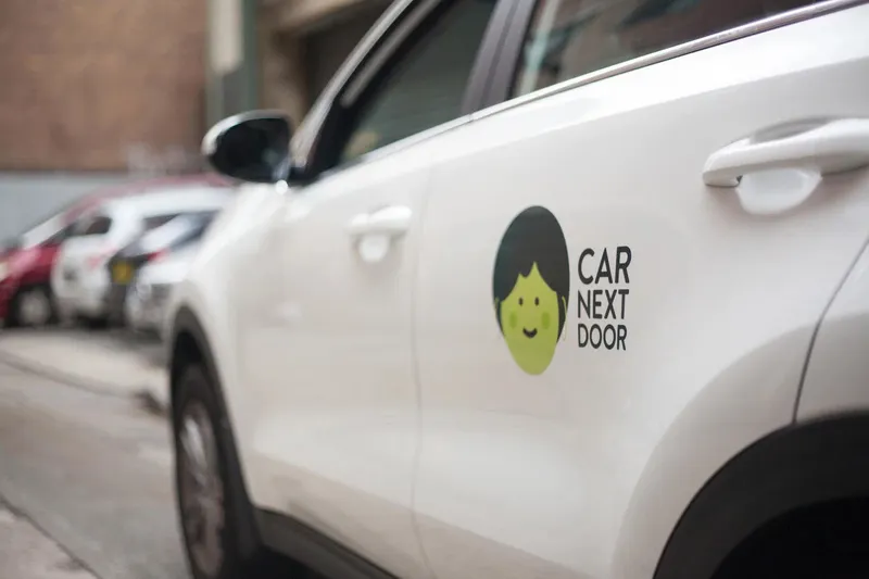 Car Next Door logo decal on a parked car door