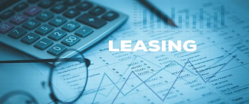 Calculator and glasses on a desk with a financial chart overlay reading Leasing