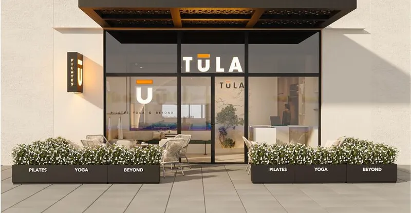 TULA storefront with pilates and yoga signage and outdoor seating