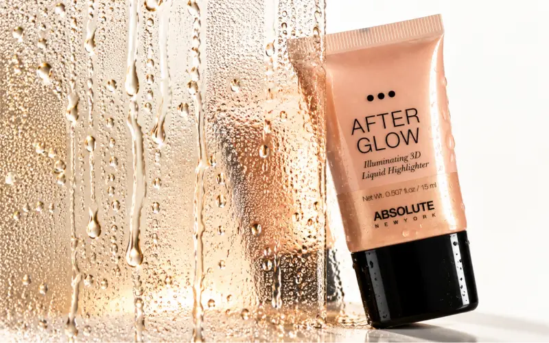 Tube of illuminating liquid highlighter beside a rain-streaked glass pane