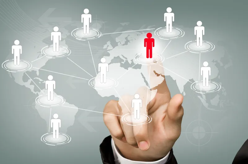 Hand touching a network of connected human-figure icons over a world map