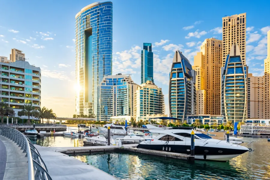 Daytime view of Dubai Marina's waterfront skyline with yachts docked in the foreground